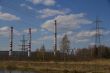 Factory pipes and high voltage power lines against the blue sky 