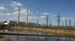 Factory pipes and high voltage power lines against the blue sky 