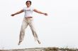 Adult smiling woman in white jumping outdoor