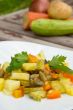 Stewed vegetables with curcuma on the white plate