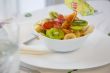 A white plate of fruit salad