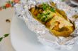 Baked potato with vegetables,chicken filet,fresh parsley and che