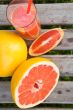 Pieces of grapefruit and a glass of fresh squeezed grapefruit ju