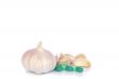 Herbal pills and garlic on a light colored background