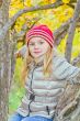 Cute girl in autumn sit on tree
