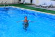 Smiling girl sailling in pool in kerchief
