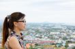 Women look at a view of the city from on high.
