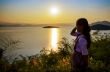 Young woman watching the sunset over the lake