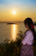Young woman watching the sunset over the lake