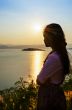 Young woman watching the sunset over the lake
