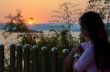Happy young woman standing watching the sunset