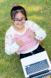 Cute girl is happy with notebook on grass