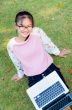 Cute girl is happy with notebook on grass