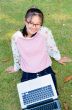 Cute girl is happy with notebook on grass