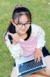 Lovely girl with a laptop on the grass