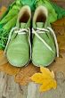 pair of green leather boots, scarf and yellow leaves
