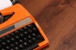 The Orange Vintage Typewriter on the Wood