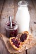 black currant jam in glass jar, milk and crackers 
