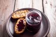 black currant jam in glass jar and crackers