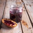 black currant jam in glass jar and cracker