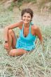 brunet woman in blue sitting in a grass