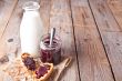 black currant jam in glass jar, milk and crackers