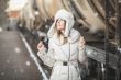 Pretty girl in winter blizzard on railroad station