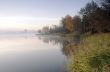 Foggy morning landscape in the autumn park near the lake.