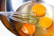 whisking eggs in metal bowl 