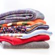 Pile of woolen jumpers of various colors and textures 