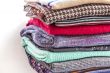 Pile of woolen jumpers of various colors and textures