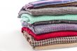 Pile of woolen jumpers of various colors and textures