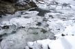 Ice covers rocks in a slow motion river in the winter 