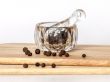 Black pepper in a transparent mortar with a pestle