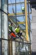 Workers wash a glass wall