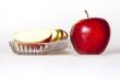 Ripe red apple and segments of apple on a plate