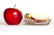 Ripe red apple and segments of apple on a plate