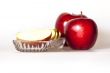 Two ripe red apples and segments of apple on a plate