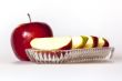 Ripe red apple and segments of apple on a plate