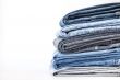 Pile of jeans of various colors on a counter in shop