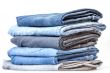 Pile of jeans of various colors on a counter in shop