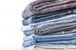 Pile of jeans of various colors on a counter in shop