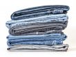 Pile of jeans of various colors on a counter in shop