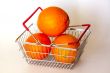 Bright large oranges in a basket for shopping