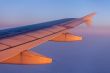 Flight at sunrise. The wing of the plane