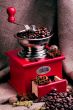 Red coffee grinder on a sackcloth background