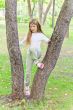 Cute girl in summer sit on tree