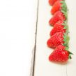 fresh organic strawberry over white wood