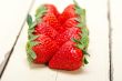 fresh organic strawberry over white wood