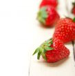 fresh organic strawberry over white wood